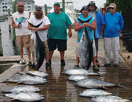 Group holding large tuna caught aboard the Carly A Outer Banks fishing charter.